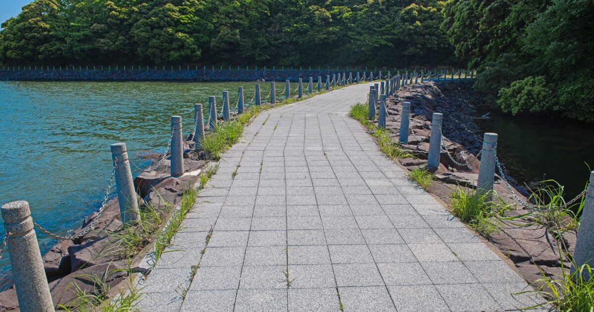 湖畔に続く石畳の遊歩道と緑豊かな景色
