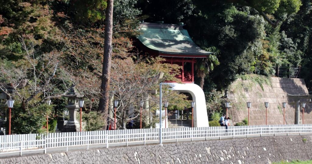 木々に囲まれた朱色の楼門と神社の参道
