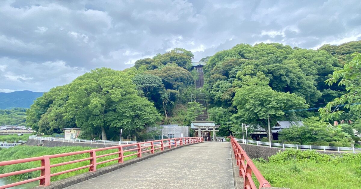赤い橋の先に続く長い石段と鳥居のある神社参道